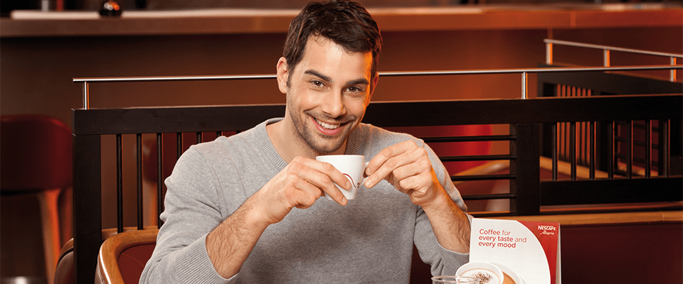 bărbați care beau cafea și zâmbesc la cameră