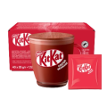 A steaming mug of KitKat cocoa beverage sits in front of a red box and a single serving packet of the drink mix.